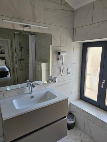 a white bathroom with a sink and a mirror at Valpino 
