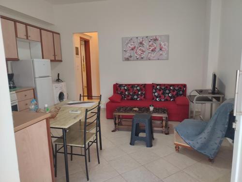 een keuken en een woonkamer met een rode bank bij Olga's House in Preveza