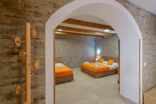 a bedroom with two beds and an archway at Domos La Corte Ghibellina in Iglesias