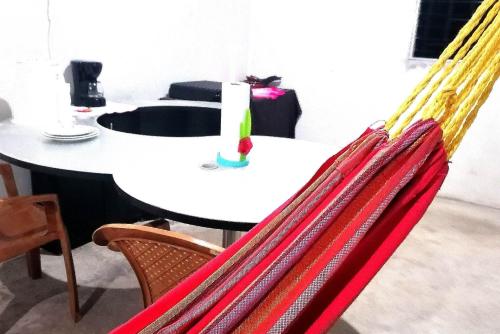 a table and chairs with red and yellow hammocks at COSTA AZUL Apartment in La Libertad