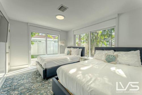 um quarto com 2 camas e uma janela em Cascada-Luxe Resort Heated Pool HotTub Wlk 2 Beach em Fort Lauderdale
