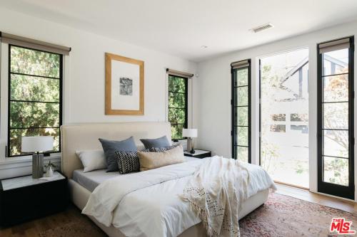 um quarto branco com uma cama e janelas em Drexel Villa em Los Angeles