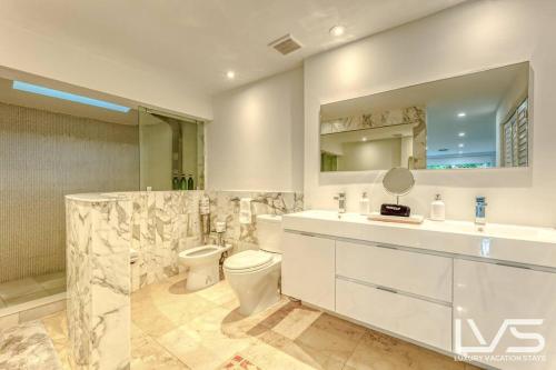 uma casa de banho com um WC, um lavatório e um espelho. em Cascada-Luxe Resort Heated Pool HotTub Wlk 2 Beach em Fort Lauderdale