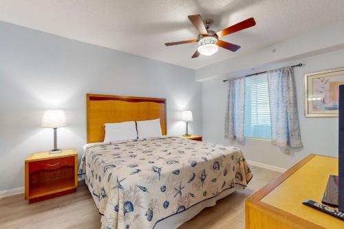 sypialnia z łóżkiem i wentylatorem sufitowym w obiekcie Ocean Walk 2424B w mieście Daytona Beach