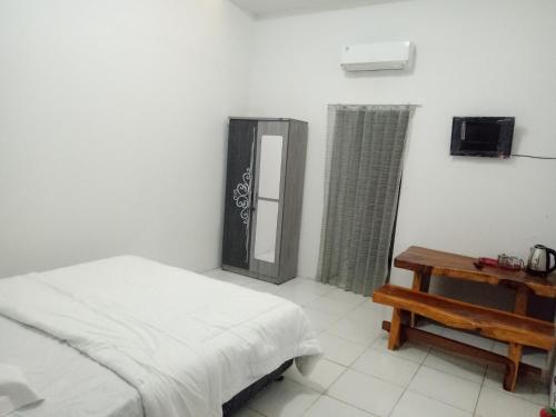 1 dormitorio con cama y mesa de madera en Mozza guest house en Klaten