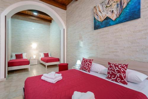 a bedroom with a red bed in a room at Domos La Corte Ghibellina in Iglesias