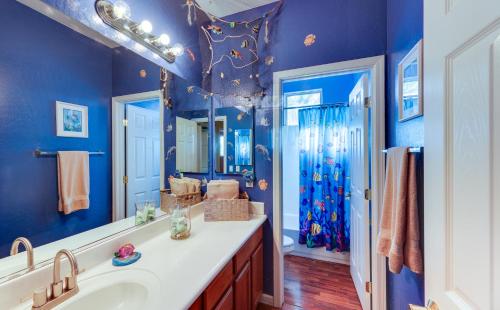 uma casa de banho azul com um lavatório e um espelho em Family Oasis with Pool, 2 Mi to Downtown Chandler! em Chandler