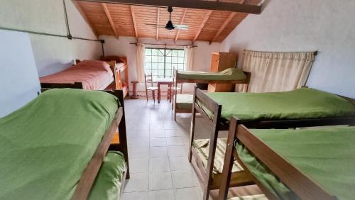 a room with three bunk beds and a table at La María Paloma in Capitán Sarmiento