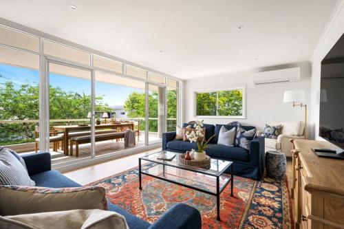 a living room with a blue couch and a table at Designer Retreat Meets Vibrant Beachside Living in Palm Beach