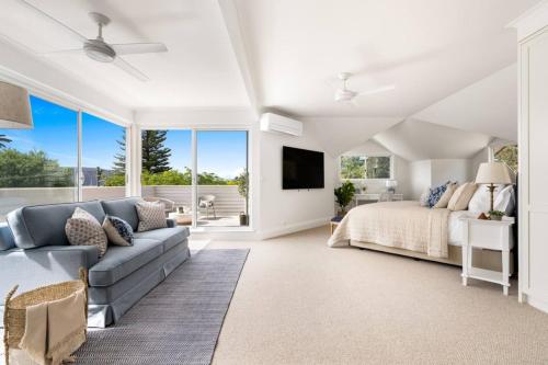 a living room with a bed and a couch at Designer Retreat Meets Vibrant Beachside Living in Palm Beach