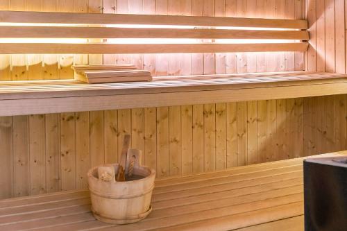 a sauna with a bucket and books on a shelf at Hotel Svea, BW Signature Collection in Simrishamn
