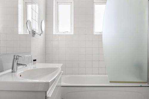 uma casa de banho branca com um lavatório e uma banheira em Hotel Svea - Sure Hotel Collection by Best Western em Simrishamn