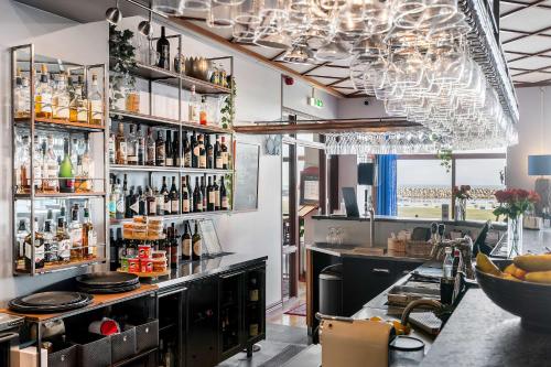 a bar in a restaurant with a chandelier at Hotel Svea - Sure Hotel Collection by Best Western in Simrishamn