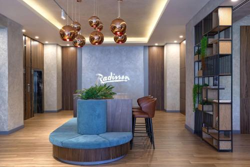 - un hall avec une table ronde et une chaise bleue dans l'établissement Radisson Hotel Baku, à Baku