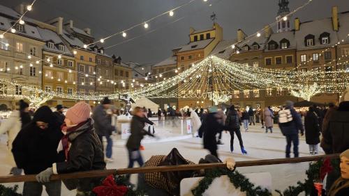 Menschen laufen auf einer Eisbahn in einer Stadt mit Lichtern in der Unterkunft Wczasowa 3 in Warschau
