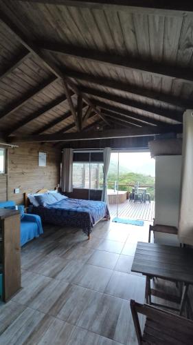 a bedroom with two beds and a wooden ceiling at Koa Cabana praia do luz in Imbituba