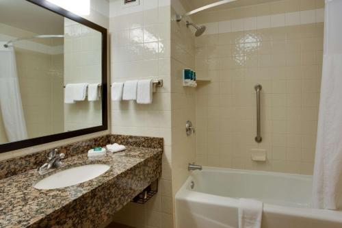 uma casa de banho com um lavatório, uma banheira e um espelho. em Drury Inn & Suites Amarillo em Amarillo