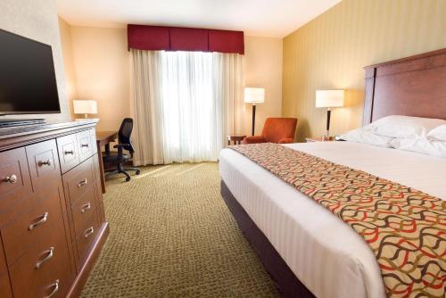 a hotel room with a bed and a flat screen tv at Drury Inn and Suites Denver Central Park in Denver