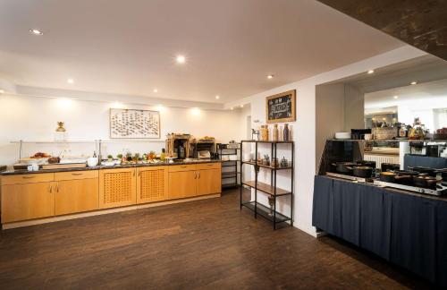 a large kitchen with wooden cabinets and a counter at ANA Living Karlsruhe by Arthotel ANA in Karlsruhe