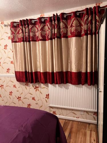 a bedroom with a bed and a curtain at A&G in Thurcaston