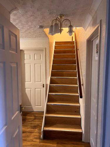 a staircase in a room with a white door and a staircase at A&G in Thurcaston