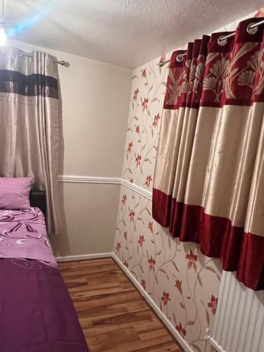 um pequeno quarto com uma cama e uma cortina em A&G em Thurcaston