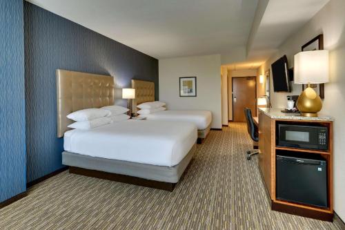 a hotel room with two beds and a television at Drury Inn & Suites Lafayette IN in Lafayette