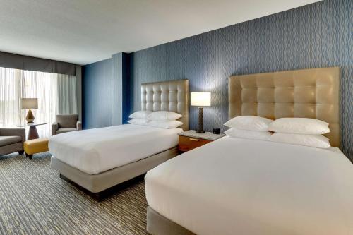 a large hotel room with two beds and a chair at Drury Inn & Suites Lafayette IN in Lafayette