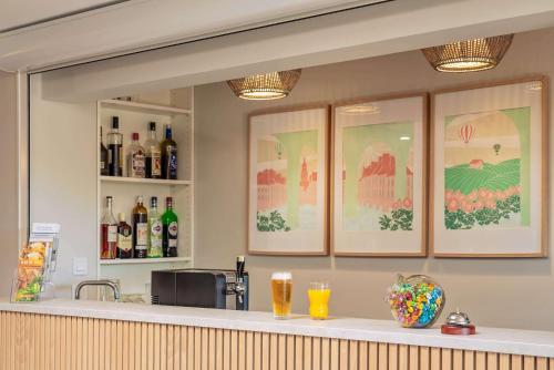 a bar with some bottles of alcohol and some drinks at Sure Hotel by Best Western Sarlat-la-Canéda in Sarlat-la-Canéda
