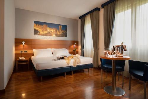 a bedroom with a bed and a table and a desk at Best Western Hotel Fiera Verona in Verona