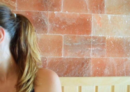 a woman with long hair looking at a brick wall at Best Western Plus Le Conquerant Rouen Nord in Bois-Guillaume