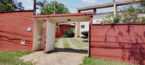 un edificio rosso e bianco con una porta bianca di Willa Hala a Vinhedo