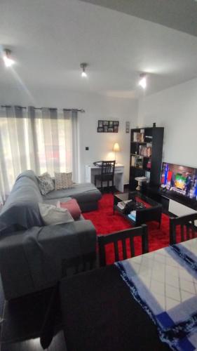 a living room with a couch and a tv at Cantinho da Fajã in Faja Grande