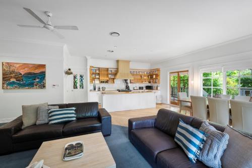a living room with two couches and a kitchen at Magical Lucindale - Gorgeous 4 Bedroom House in Lucaston