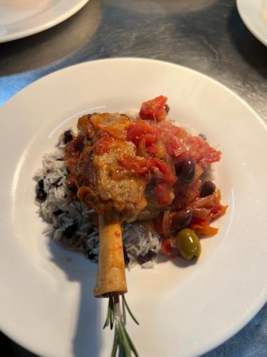 a white plate with a piece of food on top of rice at The Old Manor House Hotel in Keynsham