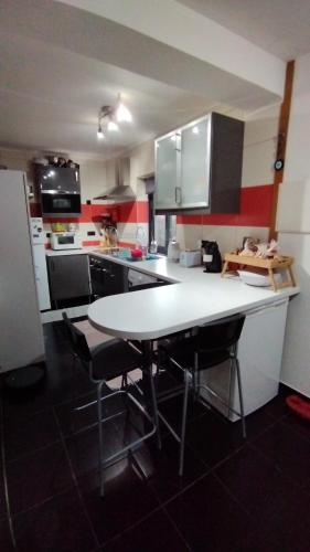 a kitchen with a white table and chairs in it at Cantinho da Fajã in Faja Grande