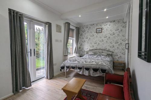 a bedroom with a bed and a table and a window at Cozy Barnhill Annex in Manchester