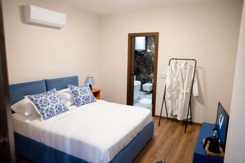 sypialnia z łóżkiem z niebiesko-białymi poduszkami w obiekcie Terra'Vista Apartments w Tiranie
