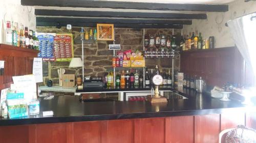 a bar with a counter with a lot of alcohol at Self catering flat in heart of Scottish Highlands in Garve