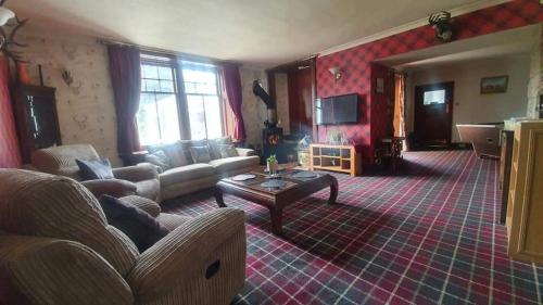 a living room with a couch and a table at Self catering flat in heart of Scottish Highlands in Garve