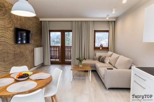 a living room with a couch and a table at Royal Hill Residence in Zakopane