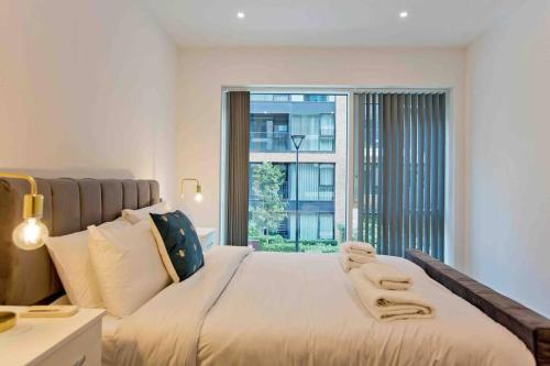 a bedroom with a large bed with a large window at Modern 1 bedroom flat with balcony in Chelsea in London
