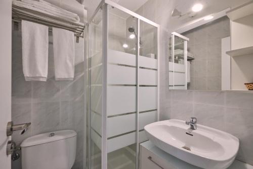 a white bathroom with a sink and a toilet at Apartamento de Julia in Santiago de Compostela