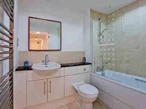 ein Badezimmer mit einem WC, einem Waschbecken und einem Spiegel in der Unterkunft Fitzrovia 2 Bed modern +Lift central London in London