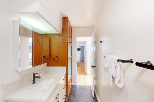 a bathroom with a sink and a mirror at Waikiki Haven in Honolulu