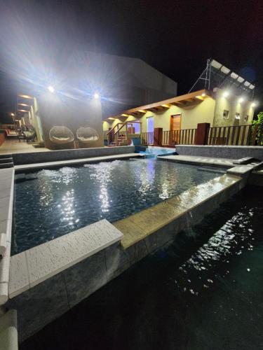 una piscina por la noche junto a un edificio en El 5to Elemento en La Falda