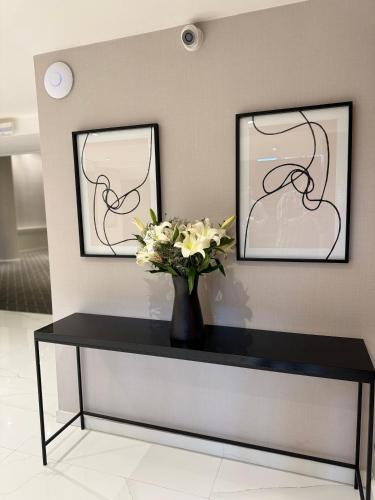 a black table with a vase of flowers on it at Guemes Hotel & Spa in Salta