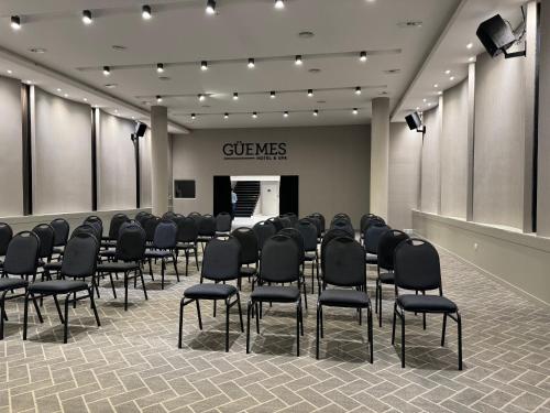 a conference room with black chairs and a podium at Guemes Hotel & Spa in Salta