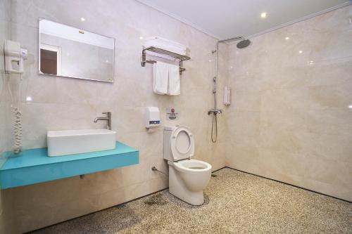 ein Bad mit einem WC und einem Waschbecken in der Unterkunft HengChang Business Hotel in Keelung