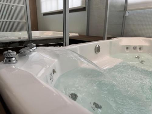 a bathroom with a jacuzzi tub with a mirror at Guemes Hotel & Spa in Salta